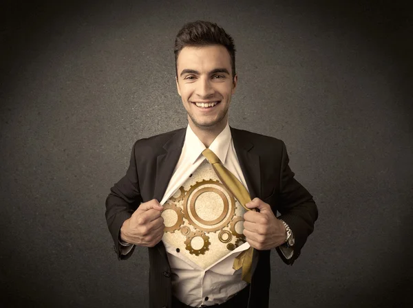 Businessman tearing shirt off and machine cog wheel shows