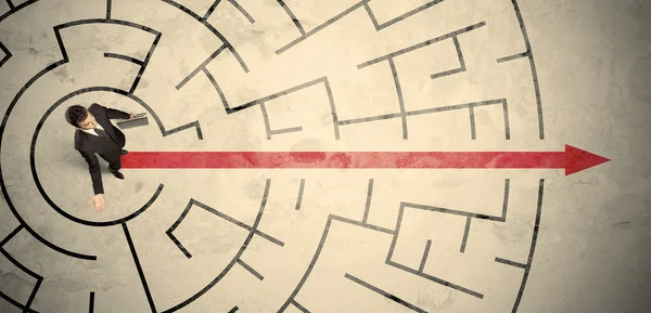 Business person standing in the middle of a circular maze