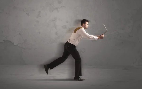 Running businessman with device in hand