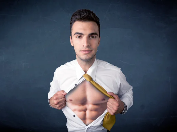 Businessman tearing off shirt and showing mucular body