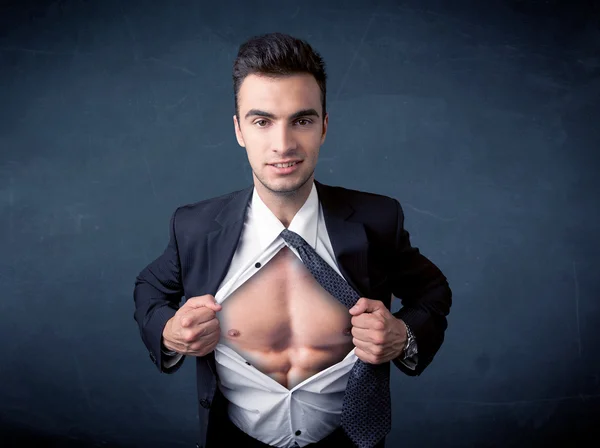 Businessman tearing off shirt and showing mucular body