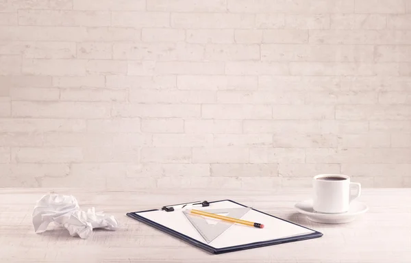 Office desk closeup with white brick wall