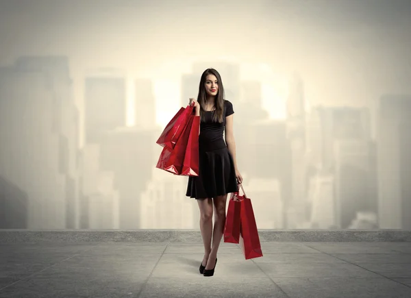 Elegant city girl with red shopping bags