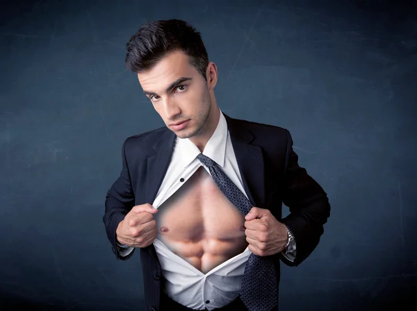 Businessman tearing off shirt and showing mucular body