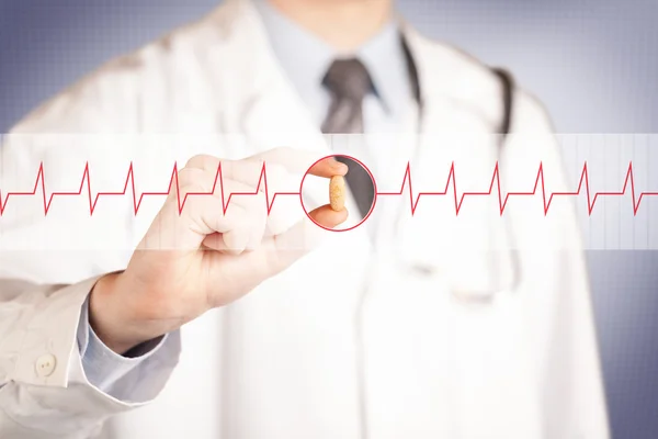 A doctor  holding a heart pill