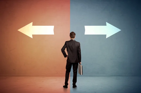 Salesman standing in front of two arrows on blue and red backgro