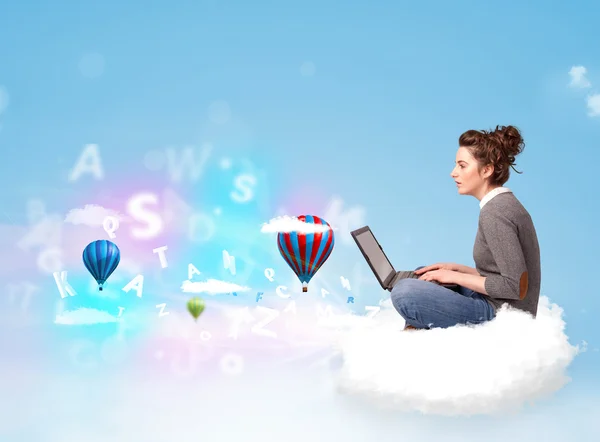 Young woman sitting in cloud with laptop