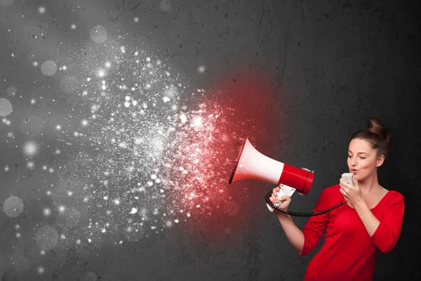 Woman shouting into megaphone and glowing energy particles explo