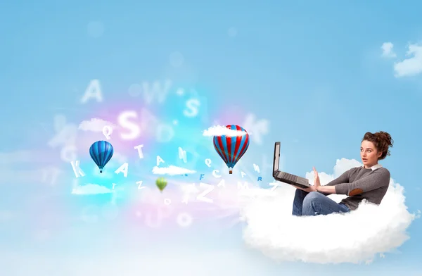 Young woman sitting in cloud with laptop