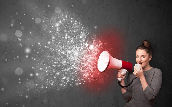 Woman shouting into megaphone and glowing energy particles explo