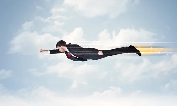 Happy business man flying fast on the sky between clouds