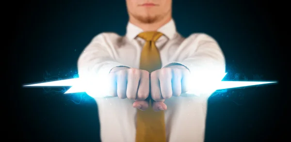 Business man holding glowing lightning bolt in his hands