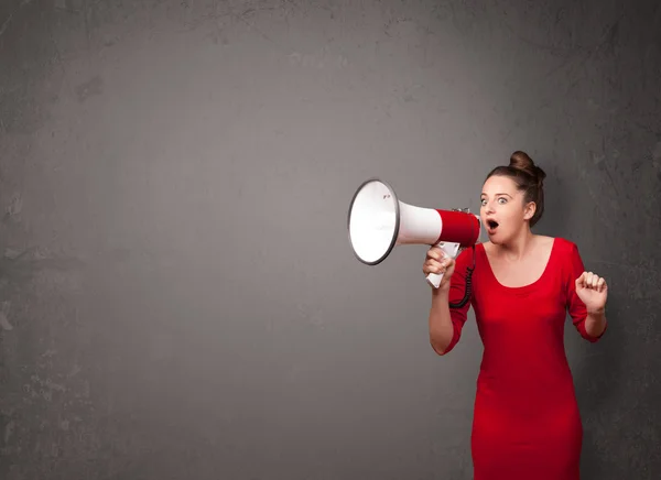 Girl shouting into megaphone on copy space background
