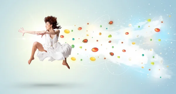 Beautiful woman jumping with colorful gems and crystals on the b