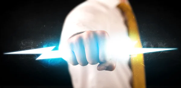 Business man holding glowing lightning bolt in his hands