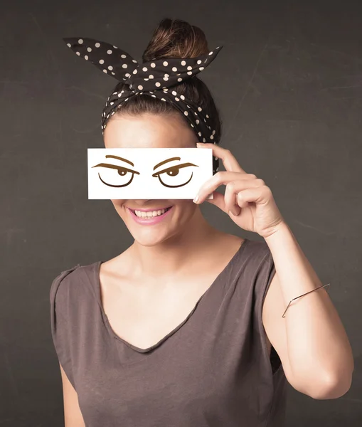 Young person holding paper with angry eye drawing