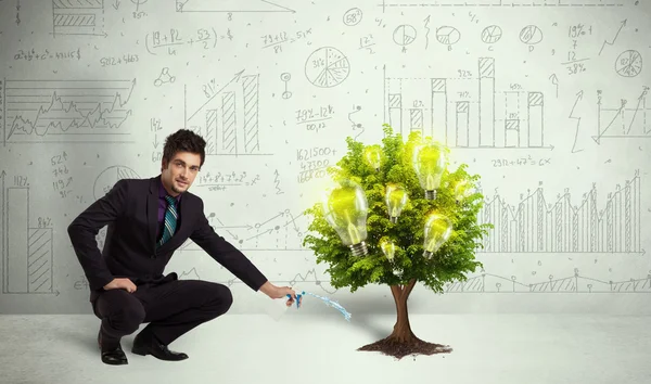 Business man pouring water on lightbulb growing tree