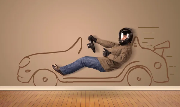 Happy man driving an hand drawn car on the wall
