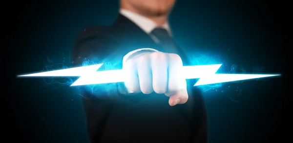 Business man holding glowing lightning bolt in his hands