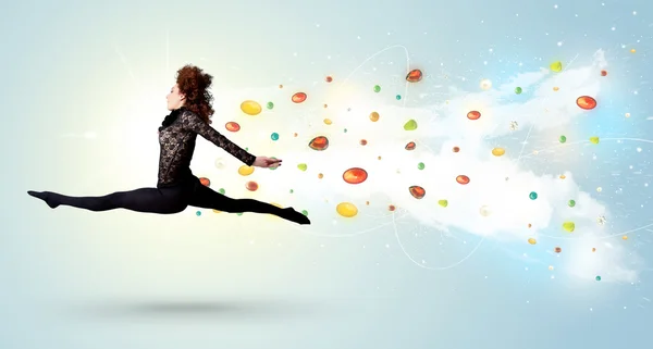 Beautiful woman jumping with colorful gems and crystals on the b