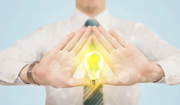 Hands creating a form with light bulb