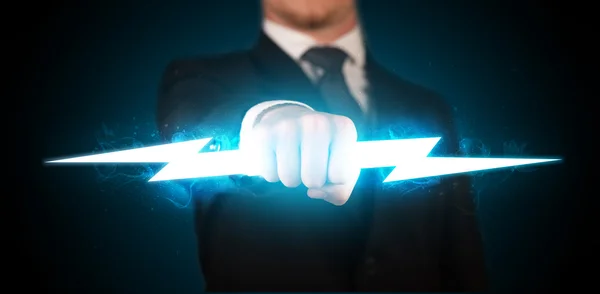 Business man holding glowing lightning bolt in his hands