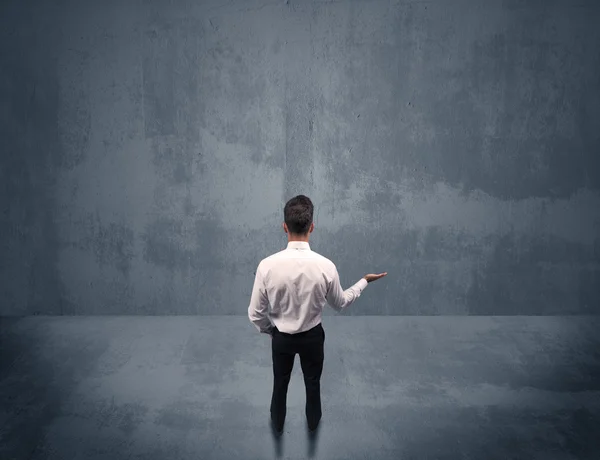 Businessman standing in front of urban wall