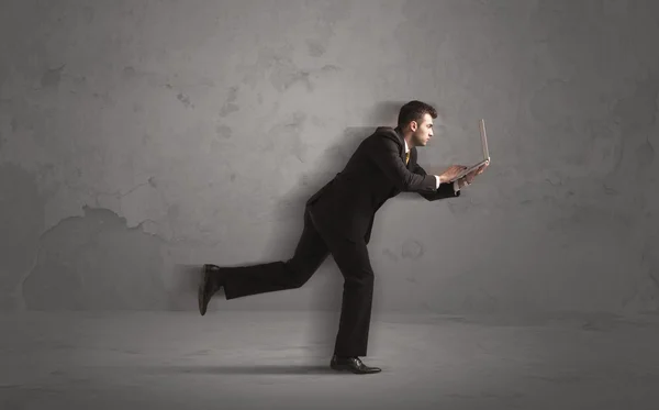 Running businessman with device in hand