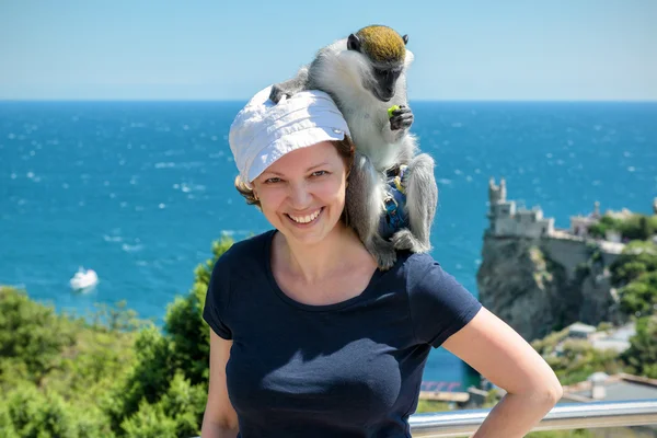 Young woman posing with a monkey on a resort in Crimea