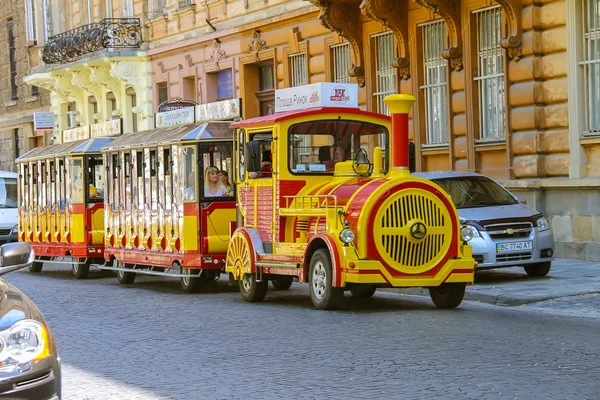Tourist tram with passengers in historical city center. Lviv, Uk