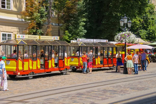 Tourist tram with passengers in historical city center. Lviv, Uk