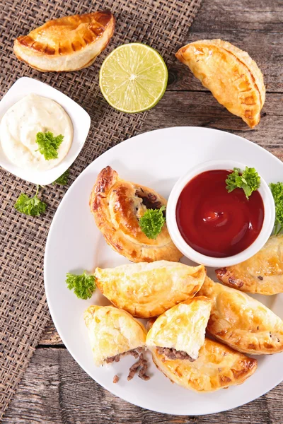 Empanada cakes with ketchup and parsley
