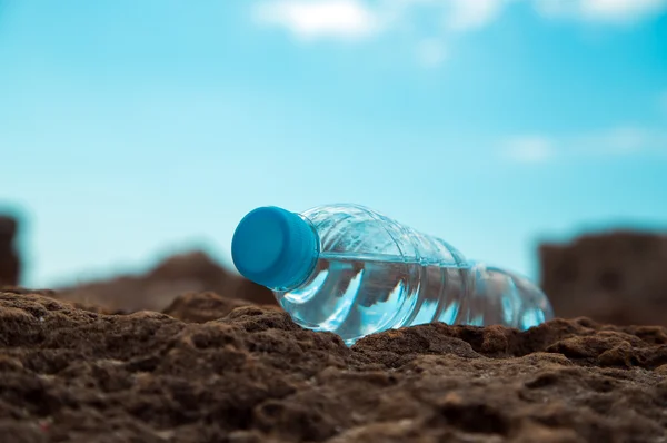 Pet bottle with water on the sea sand