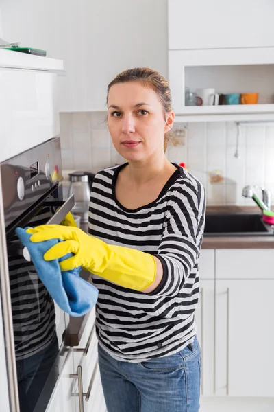 Happy young woman washing furniture at home