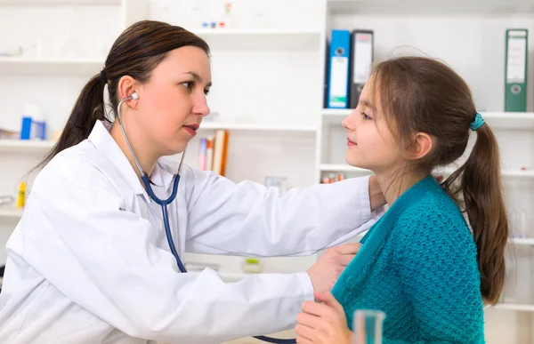 Doctor check throat of little girl.