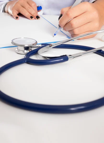 Doctor sits in a medical office in the clinic and writes medical history..toned image.