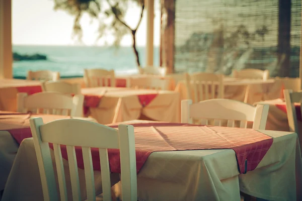 Traditional greek outdoor restaurant on terrace overlooking Mediterranean sea Greece . empty table at an street sea restaurant.