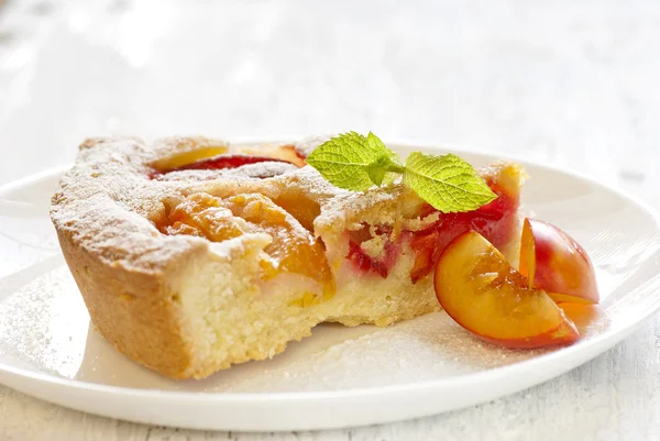 Pie with plums in powdered sugar