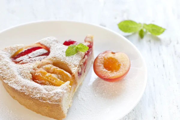Pie with plums in powdered sugar