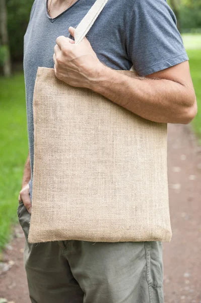 Man holding empty canvas bag. Template mock up