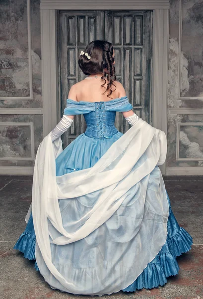 Beautiful medieval woman in blue dress, back