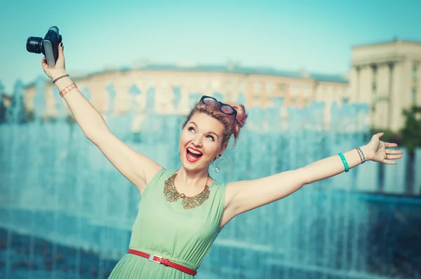 Beautiful happy girl in vintage clothing with retro camera