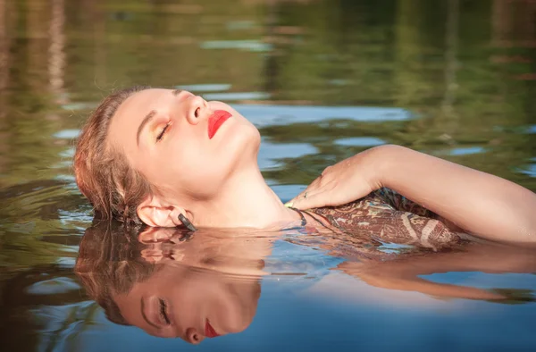 Beautiful young woman lying in the water