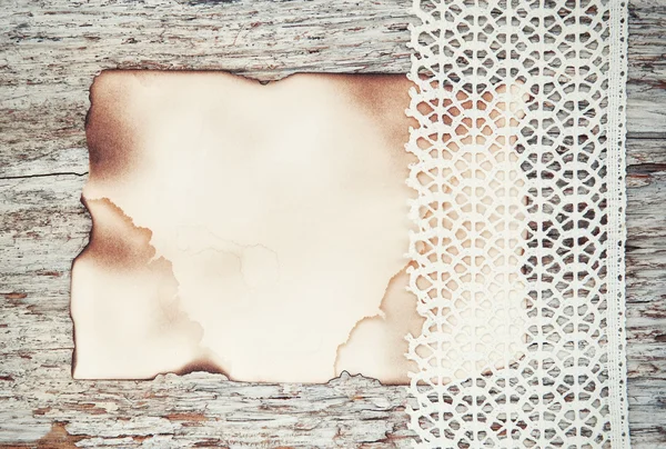 Lace fabric and aged paper on the old wood
