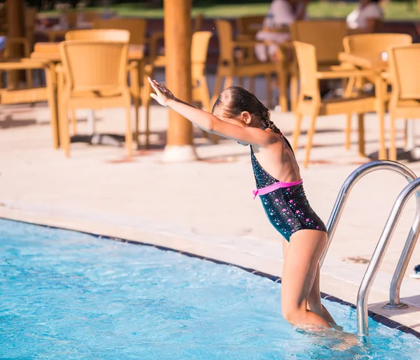 Cute little girl is ready to jump into pool