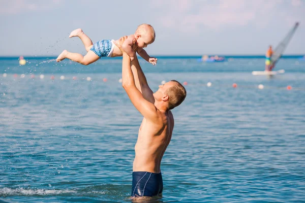 Happy father and baby having fun in the sea