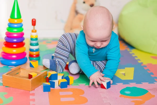 Cute little baby playing with colorful toys