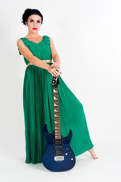 Pretty woman in long green dress with guitar