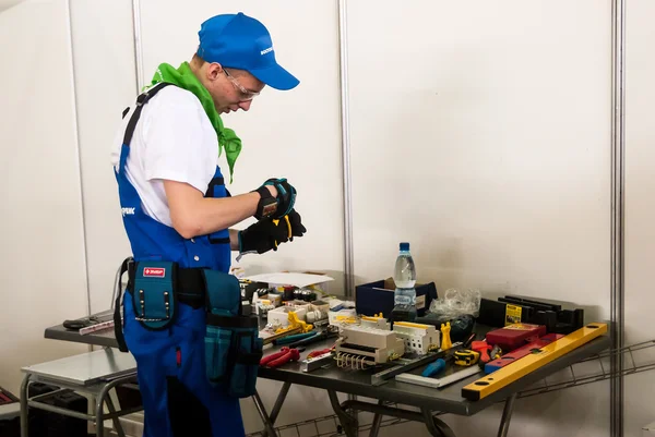 Young electrician performs task of competition