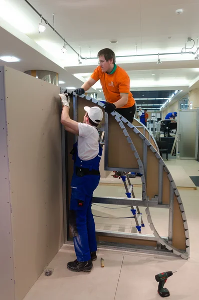 Young workers performs task with gypsum cardboard